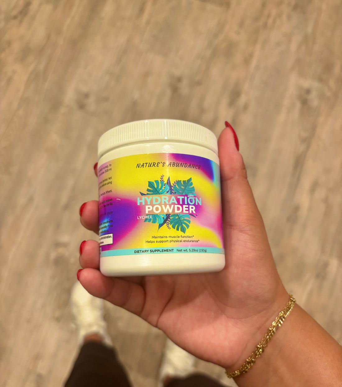 Girl holding Nature's Abundance's Hydration Powder in Lychee flavor