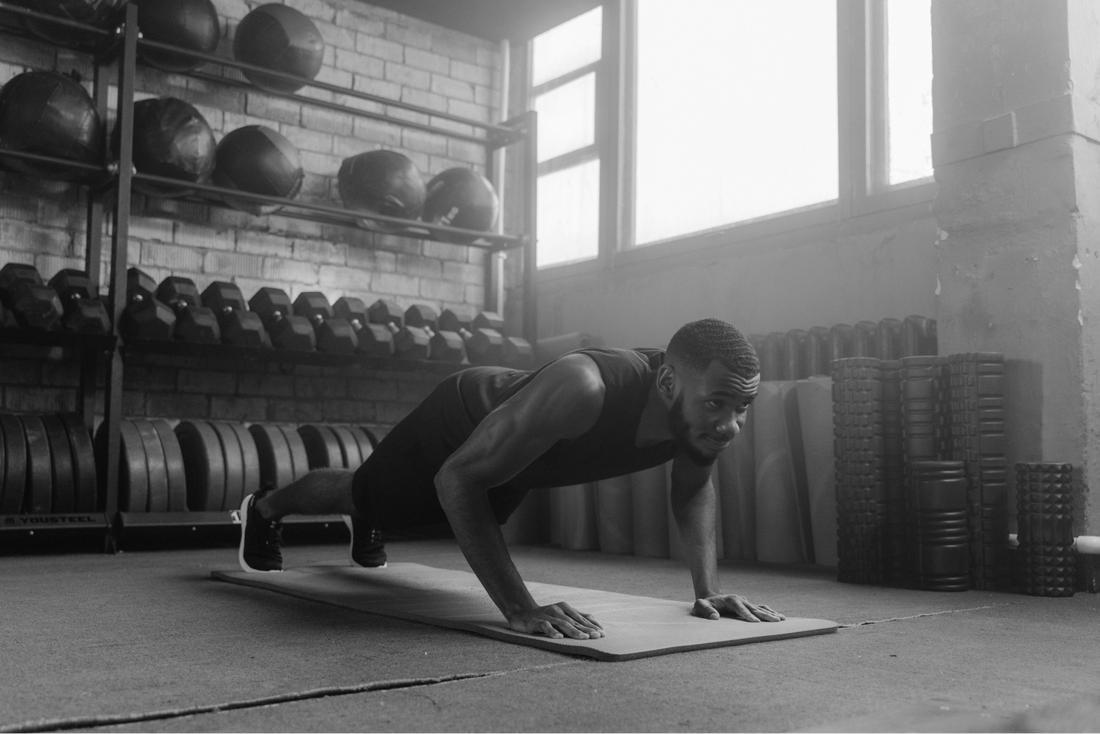 Black and White image with a man doing push ups in the gym